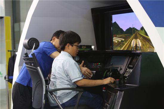 ‘2013 대한민국 행복교육기부박람회’을 찾은 참가자가 철도체험학습장에서 KTX 기장체험을 하고 있다. 
