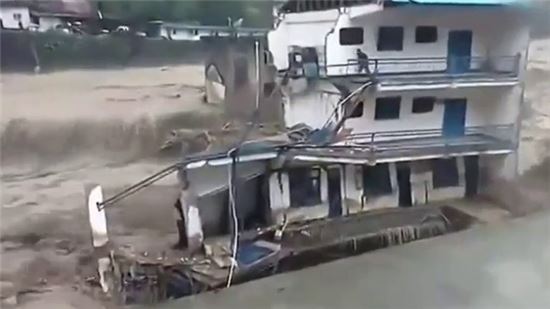 ▲ 대규모 홍수가 발생한 중국 쓰촨지역에서 홀로 건물에 고립돼 있던 남성이 급류에 휩쓸려가는 안타까운 광경이 카메라에 포착됐다.