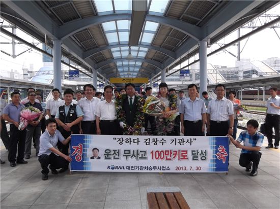 열차운전 무사고 100만km를 달성한 김창수(앞줄 가운데) 기관사가 대전역 승강장에서 축하 꽃다발을 받고 동료들과 기념사진을 찍고 있다.