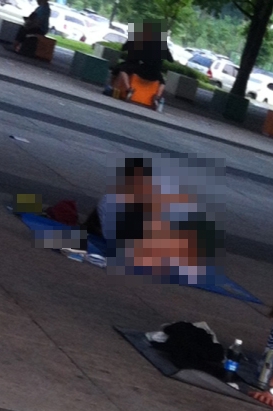 ▲ 한 10대 커플이 돗자리 위에 누워 진한 포옹을 나누고 있다.