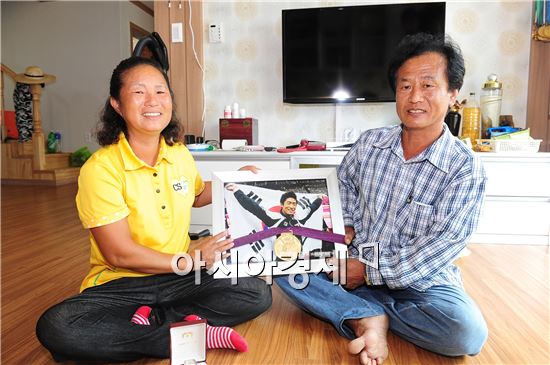 고창 공음에 지어진 새 집에 입주한 양학선 선수의 부모가 아들 사진을 들고서 기념촬영을 하고 있다.