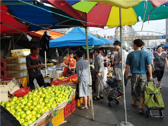 청량리 청과물 도매시장, 과일을 저렴하게 사러 온 사람들이 상인과 흥정을 하고 있다.