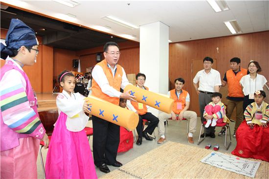 한화케미칼 임원들이 한국외국인력지원센터에서 다문화가정 아동들과 윷놀이를 하고 있는 모습. 