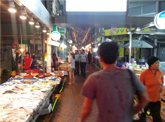지난 10일 서울 관악구 신원시장을 찾은 한 소비자가 수산물 점포를 지나가고 있다.