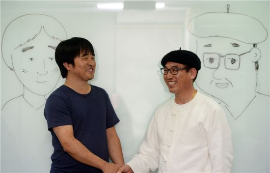 '짐승들의 사생활' 김영현 작가(오른쪽)와 삽화를 맡고 있는 박건웅 화백이 자신들의 캐리커쳐 앞에서 웃으며 이야기를 나누고 있다 