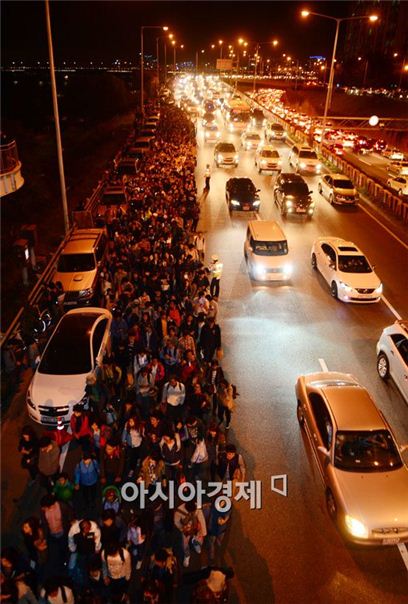 불꽃축제가 끝난 후 시민들이 도로 위를 위험하게 지나가고 있다. 