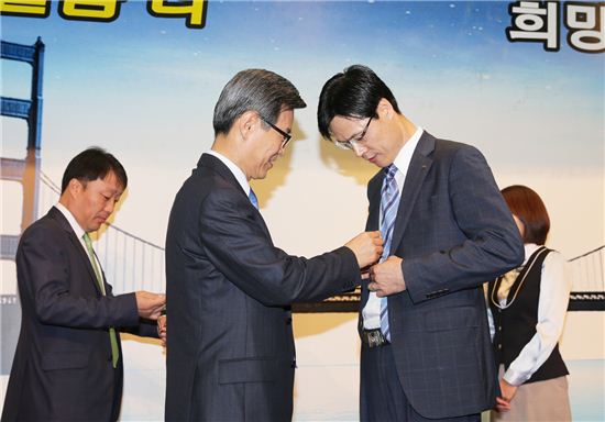 7일 창립 46주년 기념식에서 하춘수 대구은행장이 남자 직원 대표에게 '소통열쇠' 넥타이핀을 달아주고 있다.
