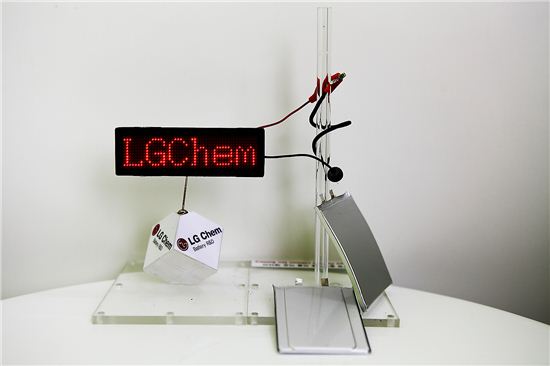 LG화학의 미래형 배터리 제품 사진. 사진 위쪽부터 케이블 배터리(투명 기둥에 감긴 검은색 케이블), 커브드 배터리(투명 기둥에 세워진 배터리), 스텝드 배터리(제일 하단에 놓인 배터리).