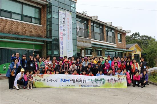 농협은행 전원생활 체험여행 참가자들이 새둥지 마을 체험 교육관 앞에서 기념촬영을 하고 있다.