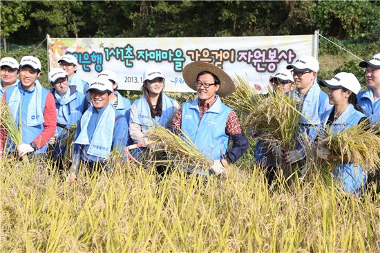 17일 이순우 우리은행장(오른쪽에서 다섯 번째)을 비롯한 임직원 100여명이 경기도 안성에 위치한 자매결연 마을에서 자원봉사 활동을 하고 있다.