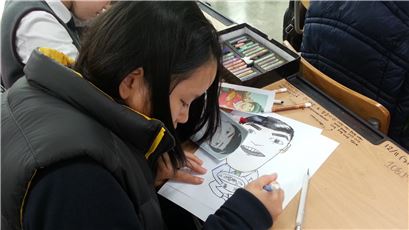 만화·사진반 수업에 참가 중인 여학생이 캐리커처를 그리고 있다. 