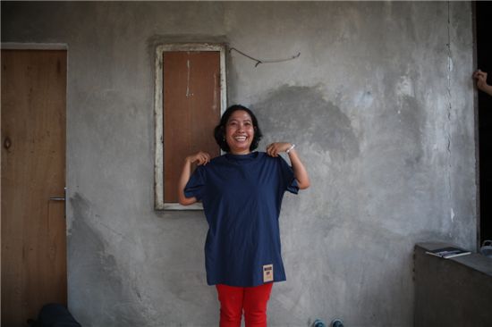 인도네시아 의류 생산 노동자가 직접 만든 'MADE BY' 티셔츠를 들고 사진을 찍는 모습. 
