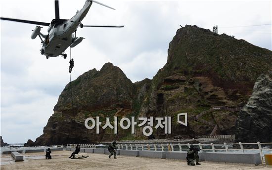 25일 오전 실시한 독도방어 훈련에서 해군 특전대대(UDT/SEAL) 및 해경 특공대 대원들이 해군 UH-60 헬기에서 강하하고 있다. 
