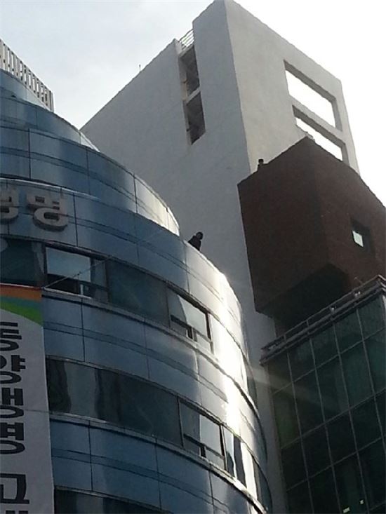 동양생명 건물 옥상에서 투신을 시도 중인 이씨 (사진:네이버 '동양 채권 CP 피해자모임' 카페)