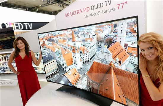 ▲LG전자 모델들이 77인치 UHD 곡면 OLED TV를 소개하고 있다.
