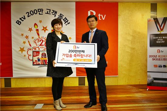 ▲안승윤 SK브로드밴드 사장이 26일 서울 중구 본사에서 열린 IPTV 'B tv' 고객 200만 돌파 기념식에서 200만번째 가입자에게 스마트TV를 증정하고 있다.