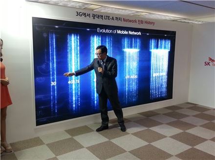 최진성 SK텔레콤 ICT기술원장이 28일  강종렬 네트워크 전략본부장이 경기도 성남시 수내동 분당사옥에서 열린 언론 시연회에서 ‘20MHz+10MHz’ 광대역 LTE-A 기술에 대해 설명을 하고 있다.