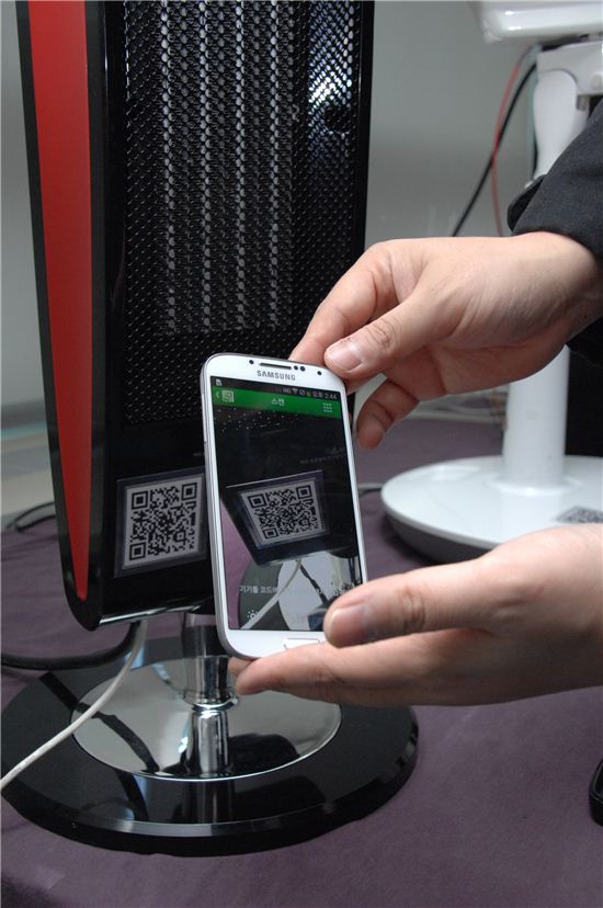 ▲ETRI 연구진이 이번에 개발한 스마트가전 기술을 응용 스마트폰으로 QR마크를 찍는 모습