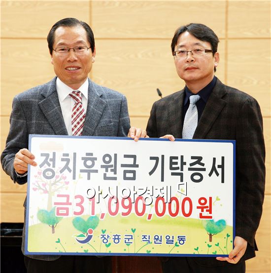 이명흠 장흥군수(왼쪽)가 장흥군선거관리위원회 채성수 사무국장에게 정치발전기금을 전달하고 기념촬영을 하고 있다.