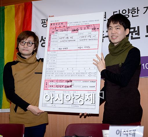 김조광수 감독(왼쪽)과 김승환 대표가 혼인신고서에 서명을 하는 퍼포먼스를 벌이고 있다. 이들은 준비한 혼인신고서를 10일 서대문구청에 우편으로 발송할 계획이라고 밝혔다. 