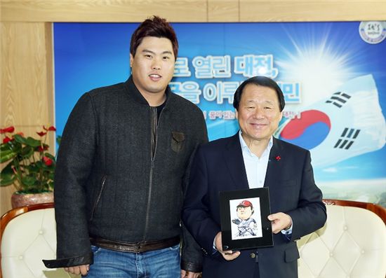 류현진(왼쪽) 선수가 염홍철 대전시장에게 자신의 캐리커쳐가 담긴 액자를 선물하고 기념사진을 찍고 있다. 



