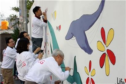 LG전자 임직원들이 서울 금천구 독산동 지역에서 벽화를 직접 그리고 있다.