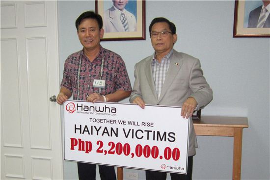 지난 12일 필리핀 아레나 공연장 신축공사현장 하권호 한화건설 상무(왼쪽)가 필리핀기독교재단(INC)측에 재해지원금을 전달하고 있다.