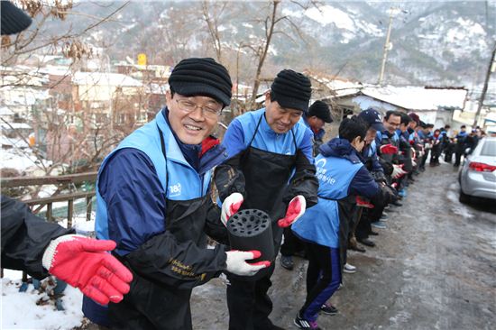 17일 서울시 상계동 양지마을에서 진행된 '서울시와 함께하는 사랑의 연탄나눔 행사'에서 이순우 우리은행장(왼쪽 첫 번째)이 참가자들과 함께 연탄 배달을 하고 있다.