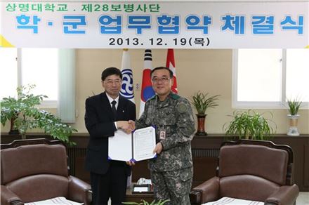 구기헌 상명대 총장(사진 왼쪽)이 이순광 육군 제 28보병사단장과 교류협력 체결한 뒤 협약서를 들어 보이고 있다.
