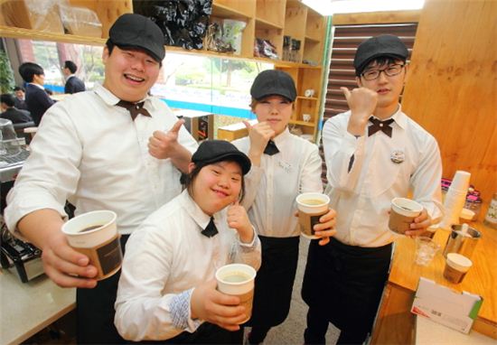 ▲사회적기업 형태의 커피전문점 '나는카페' 한국마사회지점 직원들이 환하게 웃으며 포즈를 취하고 있다. 왼쪽 두번재 직원이 김희경씨.