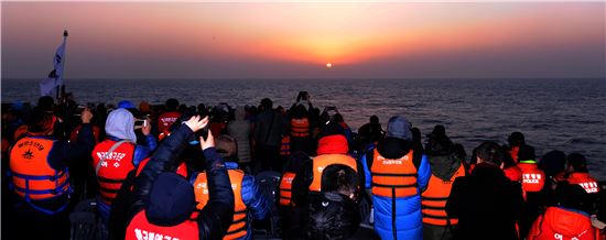 새해 일출 관람을 위해 여수해양경찰 경비함정에 승선한 시민과 관광객들이 바다위로 떠오르는 새해 첫해를 바라보고 있다.