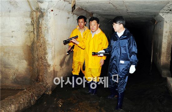 신덕마을과 도산동 일대 상습 침수 원인을 파악하기 위해 민형배 구청장이 2010년 7월 담당 공직자들과 함께 맨홀을 타고 내려가 피해지역의 하수도를 직접 점검하는 모습.