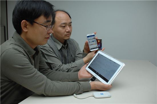 ▲ETRI 연구진이 카드를 스마트폰에 터치해 자동인증되는 '터치사인' 기술을 시연해 보이고 있다.