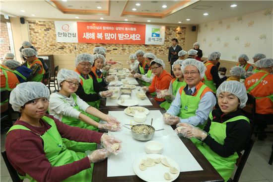 한화건설이 설을 맞아 이달 21~24일 설맞이 명절음식 나눔행사를 진행한다. 사진은 23일 이근포 한화건설 사장(오른쪽 두번째)을 비롯한 임직원들이 '동천의 집' 어린이들과 설떡국에 들어갈 만두를 빚고 있는 모습이다.