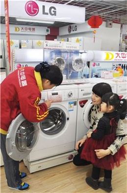 ▲중국 베이징의 가전 매장을 찾은 고객들이 LG 미니 드럼세탁기 '꼬망스' 제품을 살펴보고 있다.