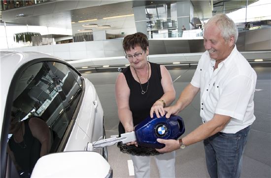 BMW 본사 근처에 있는 BMW벨트에서 고객이 새로 산 차를 전달받고 있다.