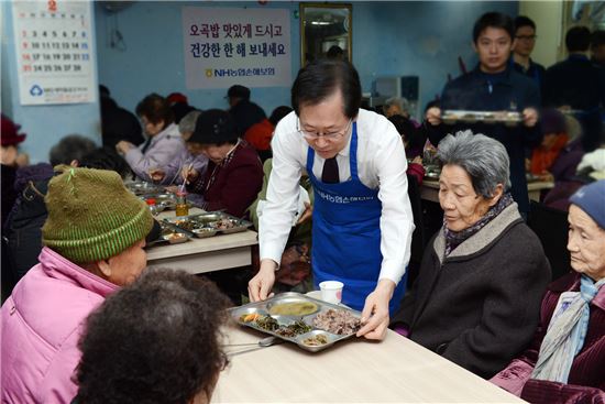 김학현 NH농협손해보험 사장(가운데)이 19일 서울 은평구 소재 무료급식소 '나눔의 둥지'를 방문에 독거노인들에게 점심식사를 제공하고 있다.
