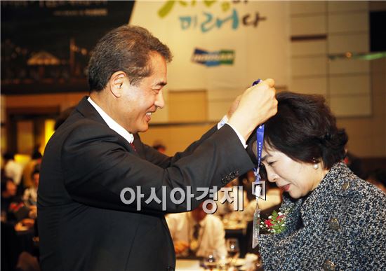 21일 창원 컨벤션센터에서 열린 두산중공업 신입사원 패밀리 데이 행사에서 두산중공업 한기선 사장(왼쪽)이 신입사원 부모들에게 명예사원증을 수여하고 있다. (사진제공=두산중공업)