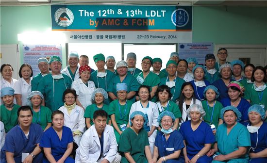 지난 22일 몽골 최초의 소아 생체간이식 수술 이후 서울아산병원 간이식팀과 몽골 현지 의료진이 함께 수술실 앞에서 기념 촬영을 하고 있다.
