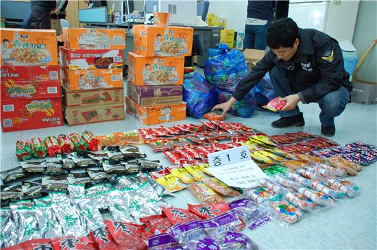 ▲해경이 중국에서 수입된 위해 식품들을 살펴보고 있다.<자료사진>