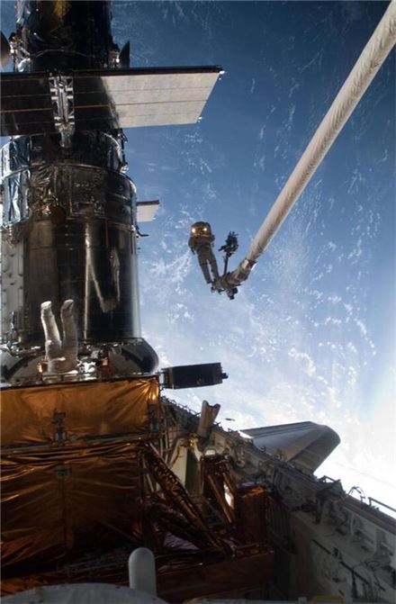 ▲2009년 허블망원경을 수리하고 있는 우주비행사.[사진제공=NASA]