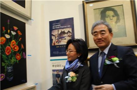 정형민 관장이 유진룡 장관과 함께 정부미술품구입 표시로 안창홍작가의 작품 '꽃'에 빨간 스티커를 붙이고 있다.  
