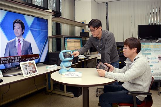▲ETRI 연구진이 차세대스마트TV연구단 실험실에서 퀴즈를 보며 스마트패드와 로봇인 키봇으로 연동한 증강방송을 시연하고 있다.
