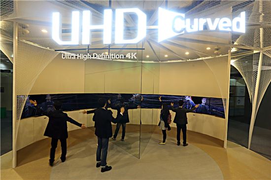 ▲26일부터 서울 삼성동 코엑스에서 열리는 '2014 서울리빙디자인페어'에서 삼성전자 관람객들이 커브드 UHD TV로 꾸민 조형물을 체험해 보고 있다.