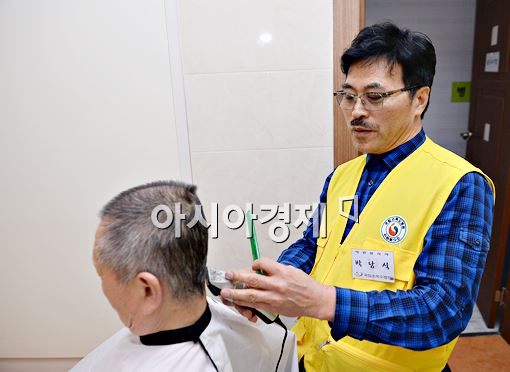 박준 원장이 국립소록도병원에서 한 환우의 머리를 다듬고 있다.
