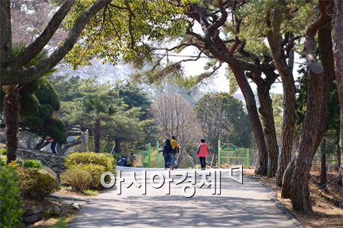 국립소록도병원 중앙공원 입구. 관광객들이 사철 푸른 소나무와 만개한 꽃들로 봄 분위기 물씬 풍기는 소록도 공원으로 들어가고 있다.