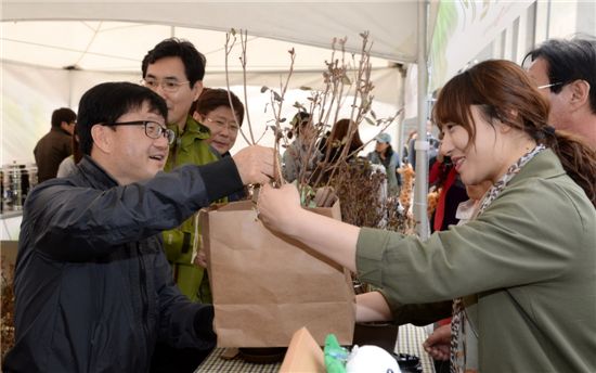 신원섭(맨왼쪽) 산림청장이 식목일을 맞아 지난 3월27일 서울 광화문광장에서 열린 '내 나무 갖기 한마당' 행사에 참석, 시민들에게 연산홍을 나눠주고 있다. 