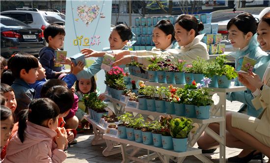 2일 오전 서울 대한항공 서소문 사옥에서 대한항공 승무원들이 어린이들에게 ‘미모사 재배 키트(Kit)’를 나눠주고 있는 모습.
