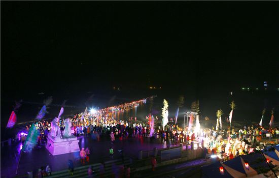 <진도군은 ‘신비의 바닷길 축제’에 처음으로 새벽에 횃불을 들고 뽕할머니를 맞이하는 퍼포먼스를 열었다. 그러나 국내·외 관광객 1000여명이 참여한 이 퍼포먼스는 바닷길에 발목까지 물이 차올라 관광객들이 어려움을 겪었다.>
