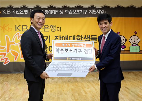 이건호 국민은행장(왼쪽)이 변승일 한국장애인단체총연맹 상임대표와 '2014년 새내기 대학생 학습보조기구 전달식'을 갖고 기념촬영을 하고 있다.